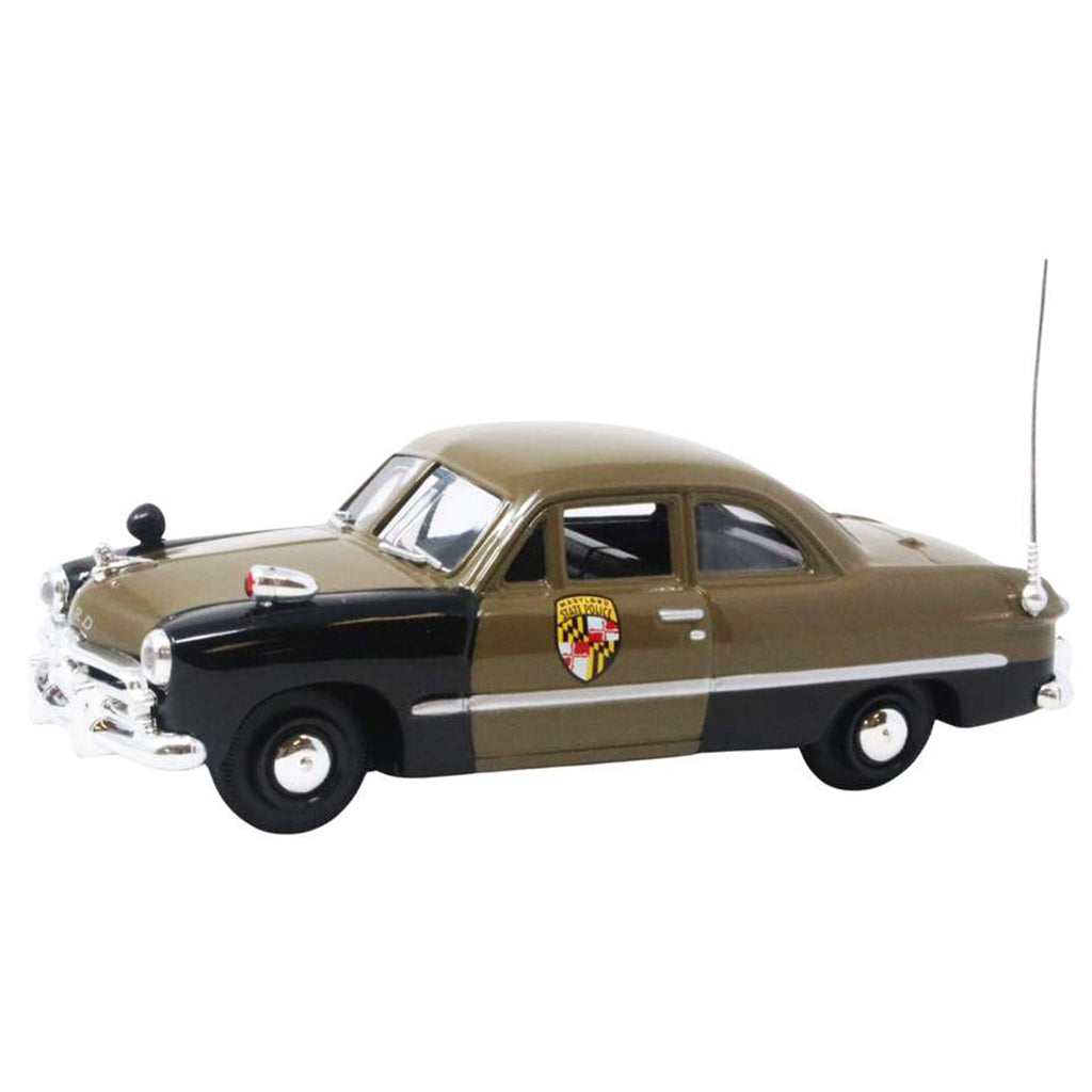 Model of a vintage police car with a brown body and black roof on a white background