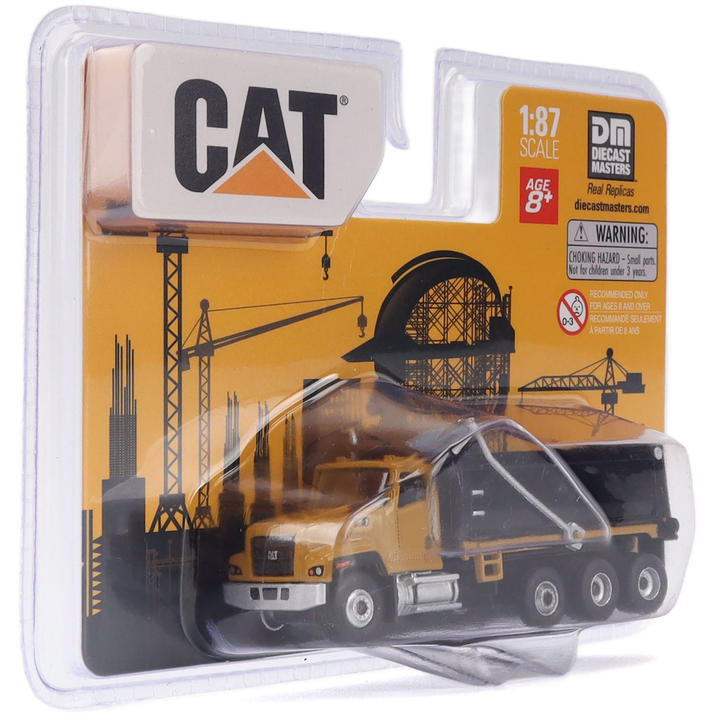 CAT 1:87 scale diecast toy dump truck in its original blister packaging by Decast Masters. The yellow and black truck is shown inside a clear plastic blister pack with a yellow and black cardboard backing card featuring the CAT logo and construction crane graphics.