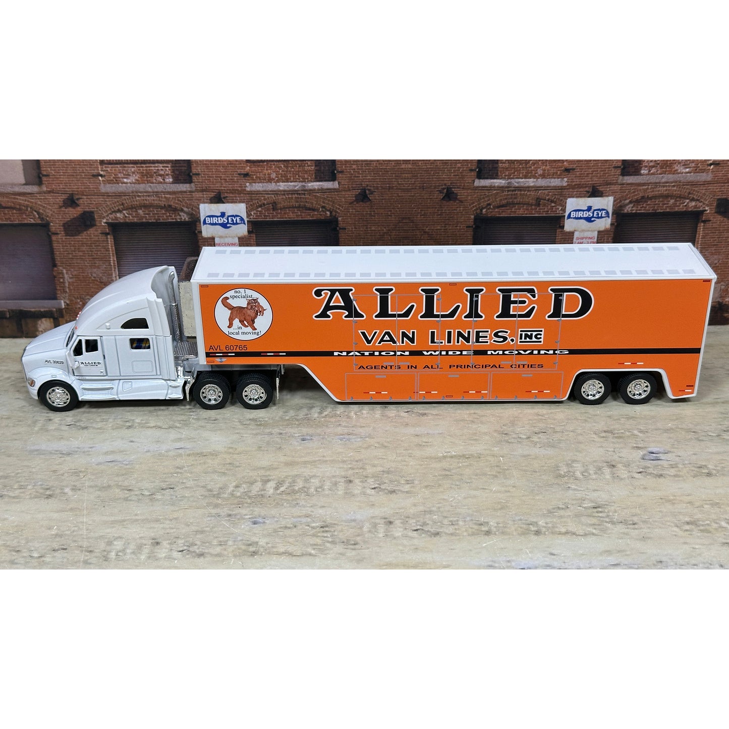Model truck with 'Allied Van Lines' branding on a wooden surface.