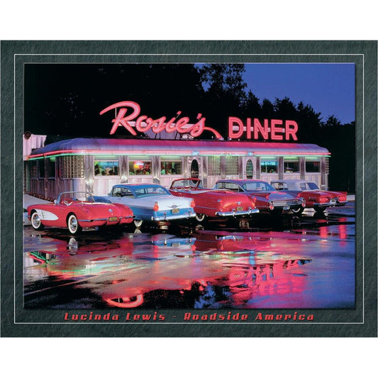 Vintage diner with classic cars in front, illuminated by neon lights at night.