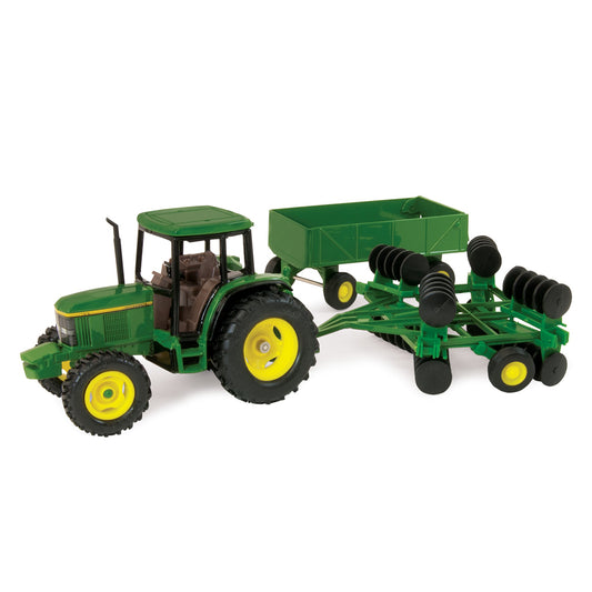 Toy John Deere tractor with a green trailer and disk attachment on a white background