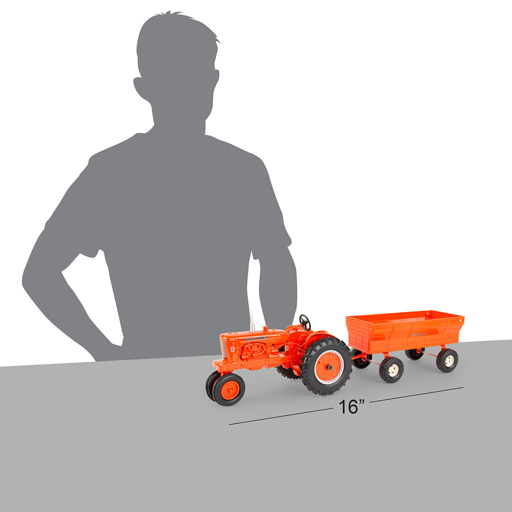 Orange toy tractor with a trailer next to a person's silhouette for scale on a white background