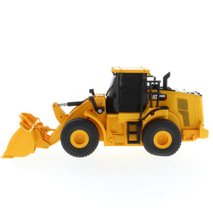 A yellow and black radio controlled wheel loader with a front bucket loader, photographed on a clean white background. The brand name CAT is visible on the side of the cab.