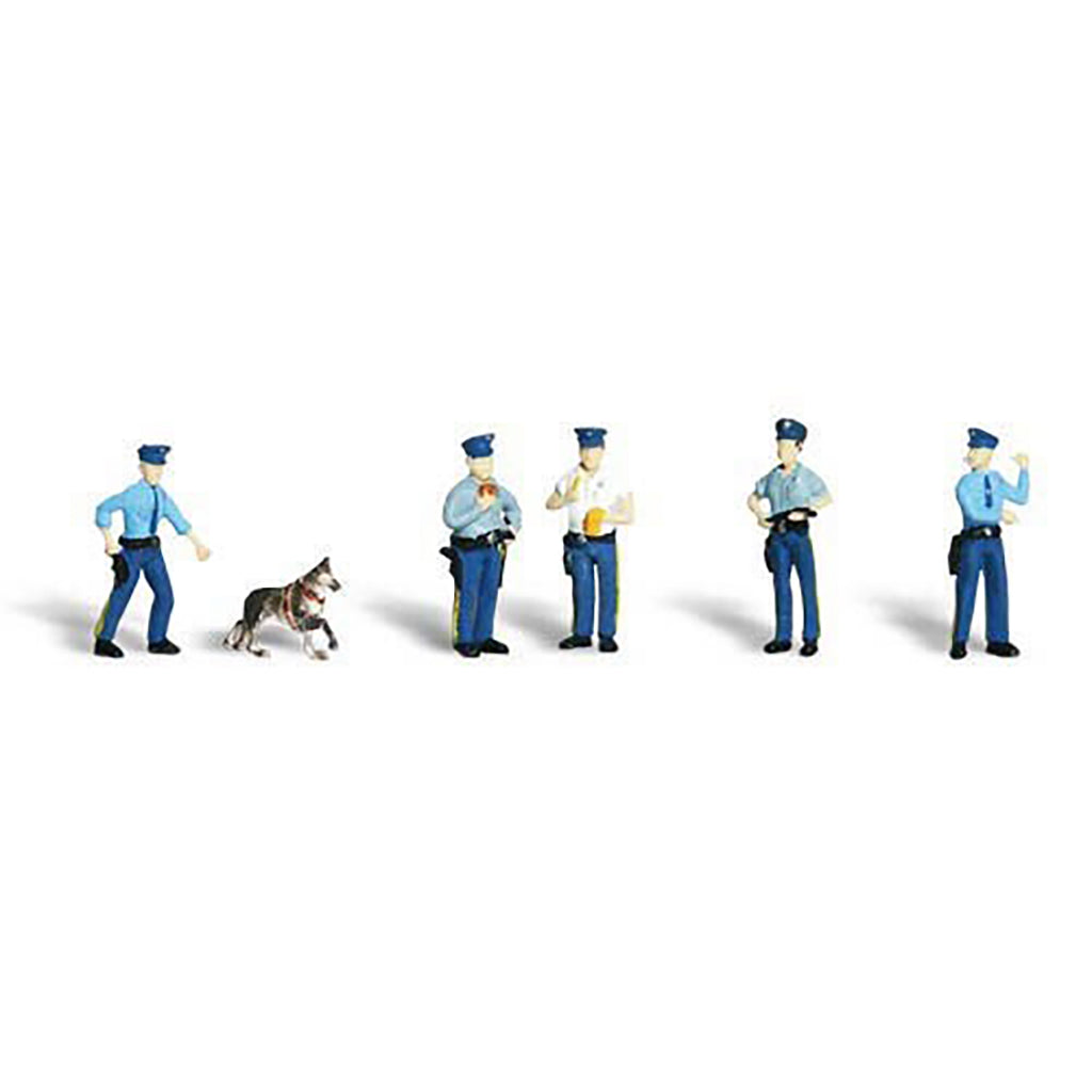 A set of miniature toy police officer figures and a small dog, shown standing on a plain white background.