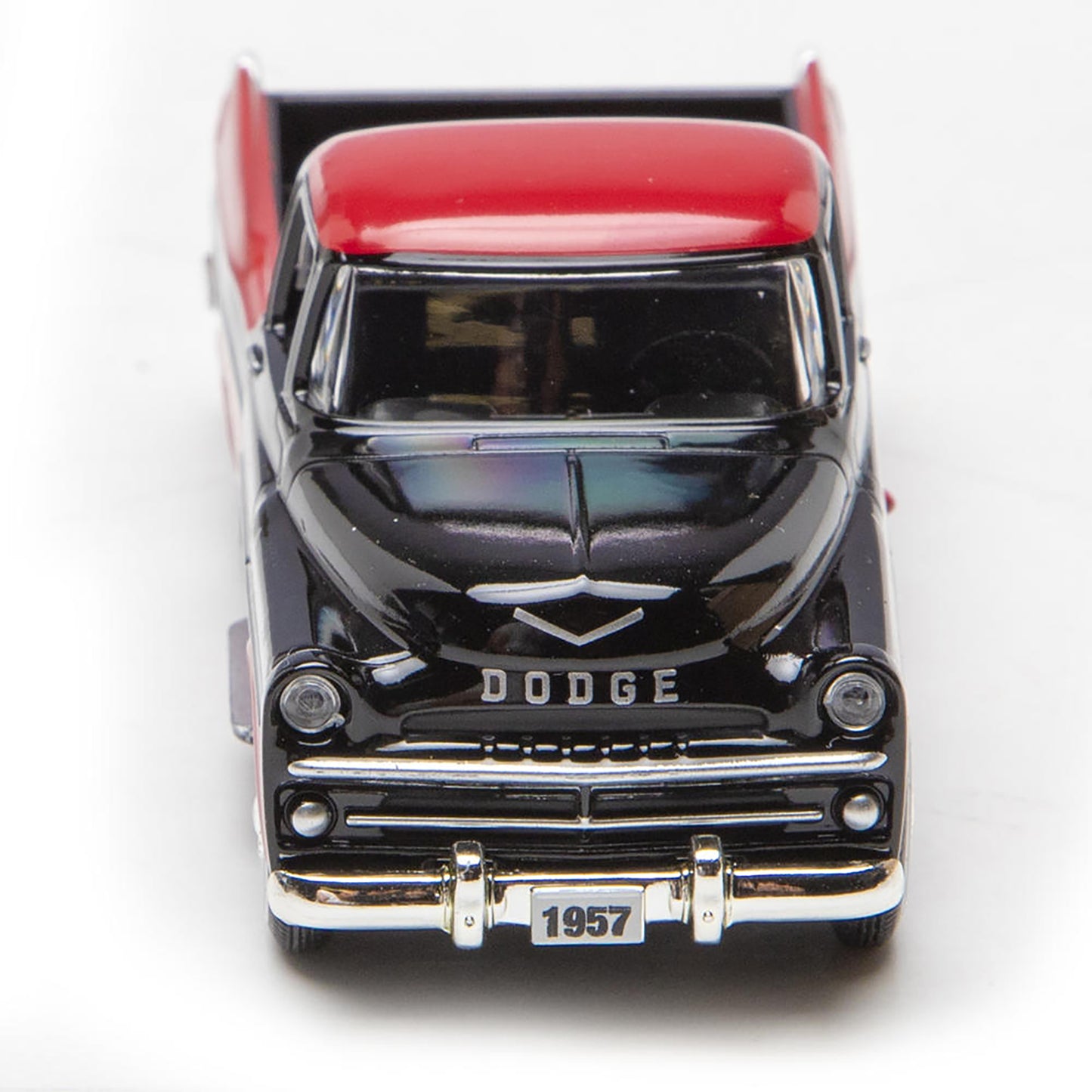Model of a 1957 Dodge truck with a red bed on a white background
