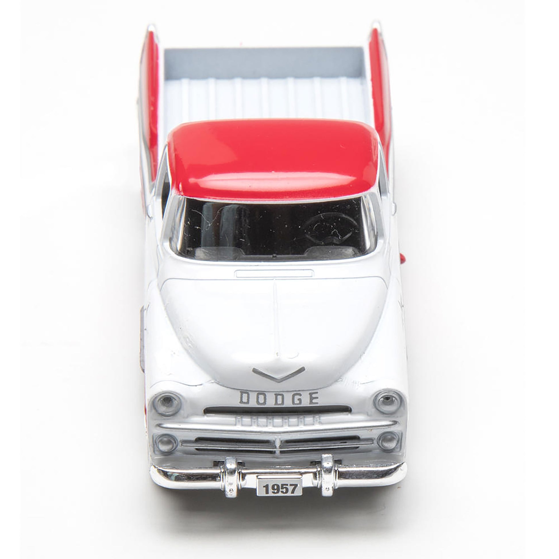 Model of a 1957 Dodge truck with a red bed on a white background
