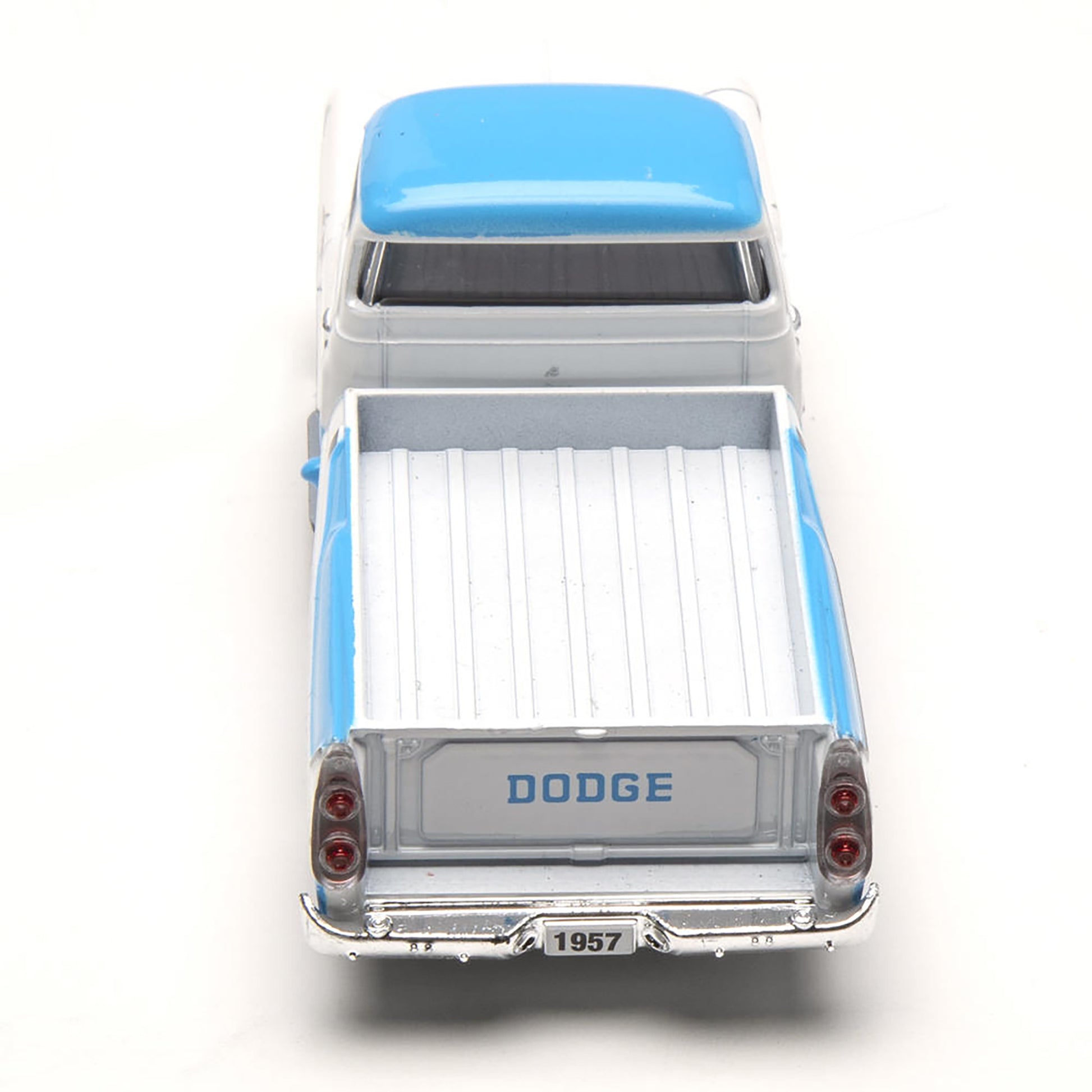 Model of a 1957 Dodge truck with a blue roof on a white background