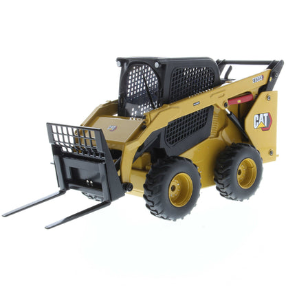 Radio Controlled Model of a CAT Yellow and Black Caterpillar 272D3 Skid Steer Loader with Pallet Forks on a White Background