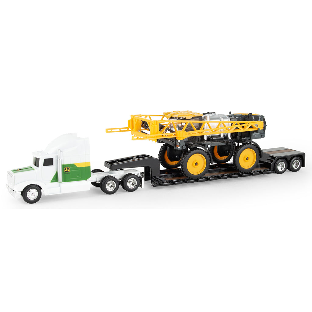 Toy truck with a flatbed carrying a larger toy Hagie sprayer on a white background