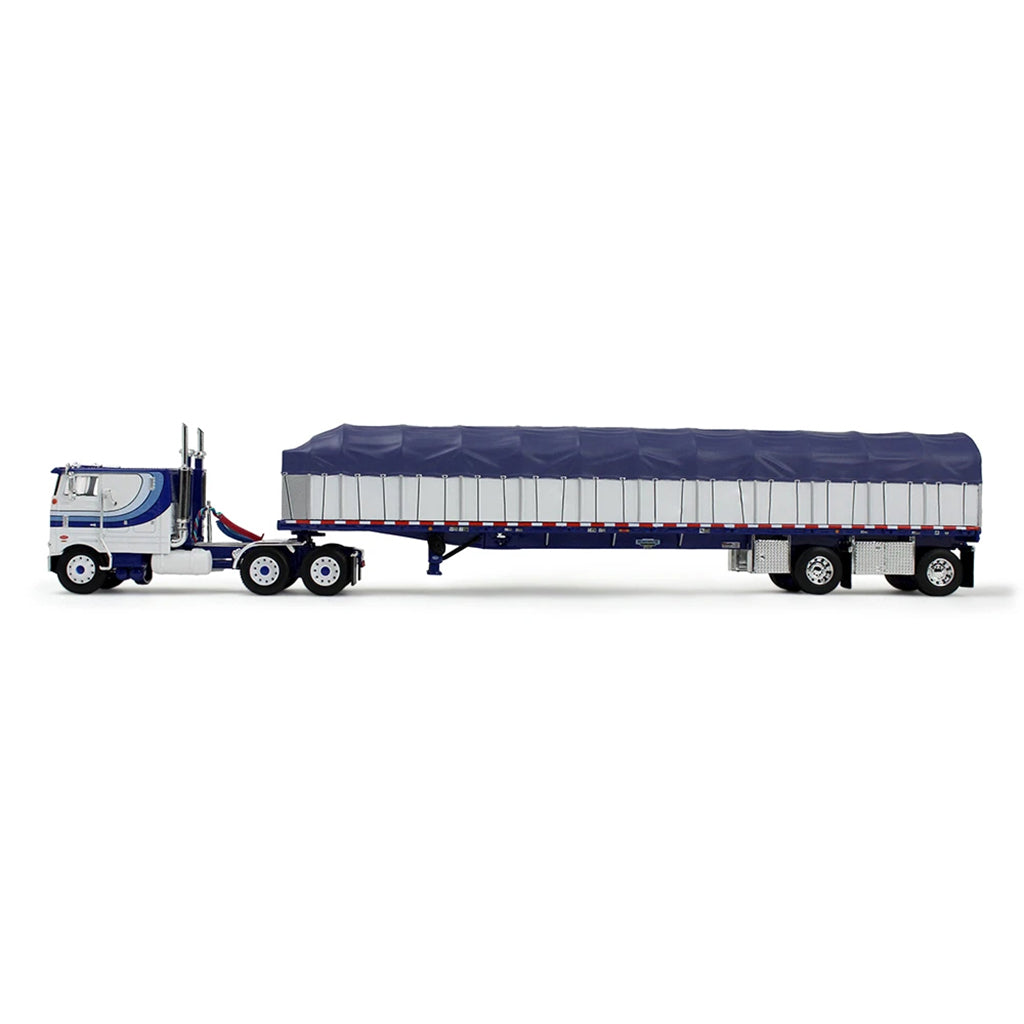 A die-cast model of a classic Peterbilt Cab-Over semi-truck with a White and blue cab, towing a long white with blue canvas-covered trailer, shown on a plain white background.