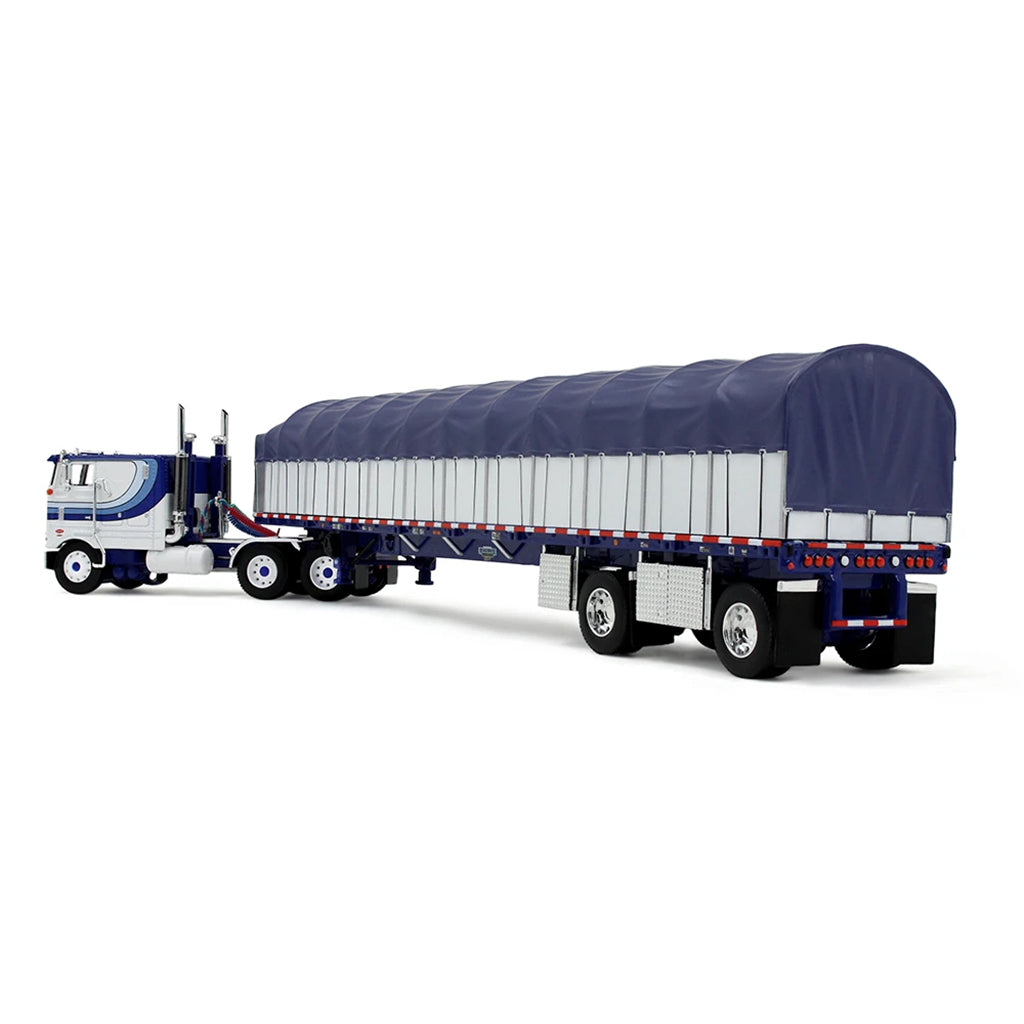 A die-cast model of a classic Peterbilt Cab-Over semi-truck with a White and blue cab, towing a long white with blue canvas-covered trailer, shown on a plain white background.