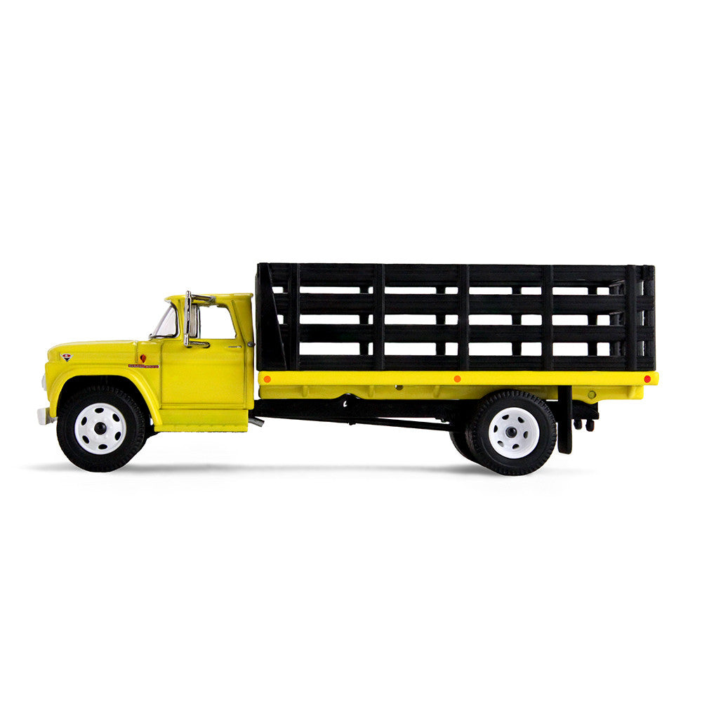 A yellow vintage GMC stake truck with a black slatted cargo bed on a clean white background.