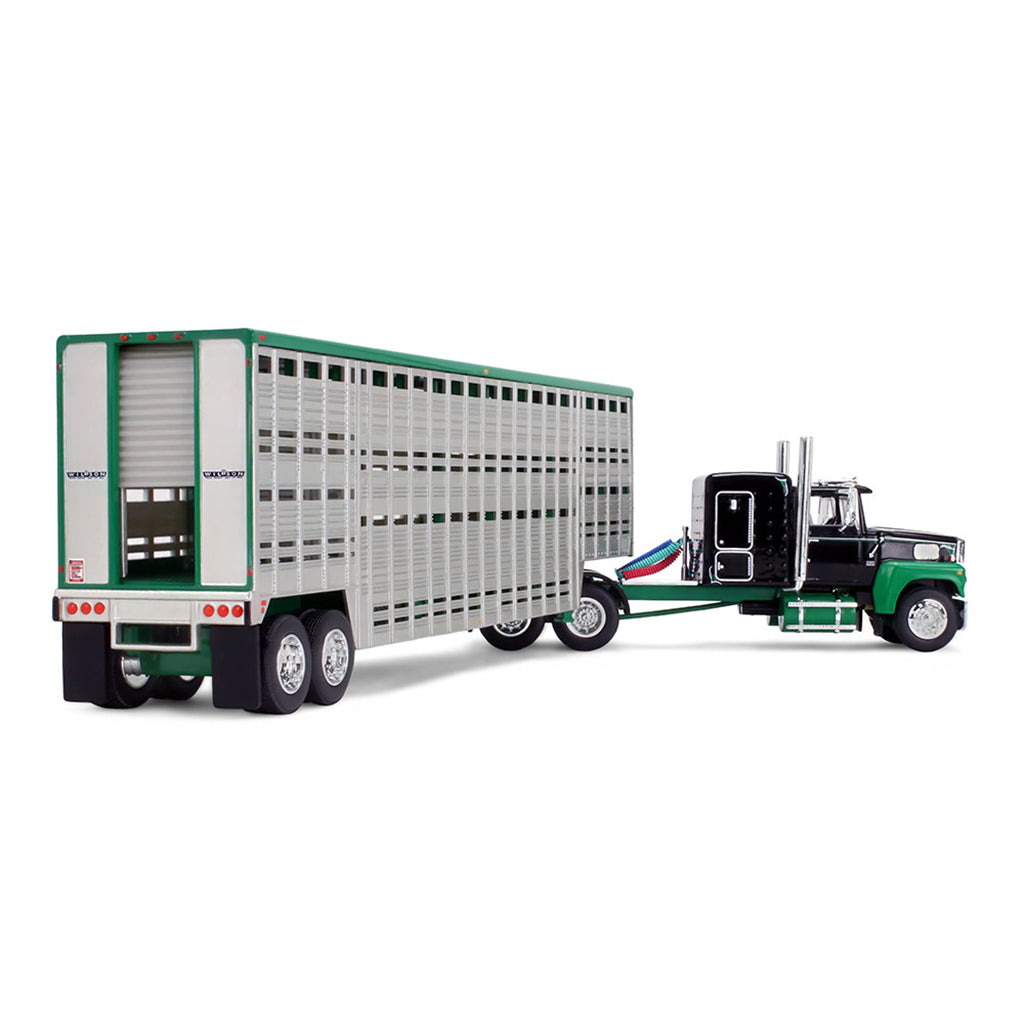 A die-cast model of a green and black semi-truck towing a silver livestock trailer with a green roof, shown on a plain white background.