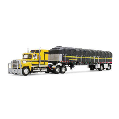 A model of a yellow semi-truck pulling a long black covered wagon trailer with yellow stripes, shown on a plain white background.
