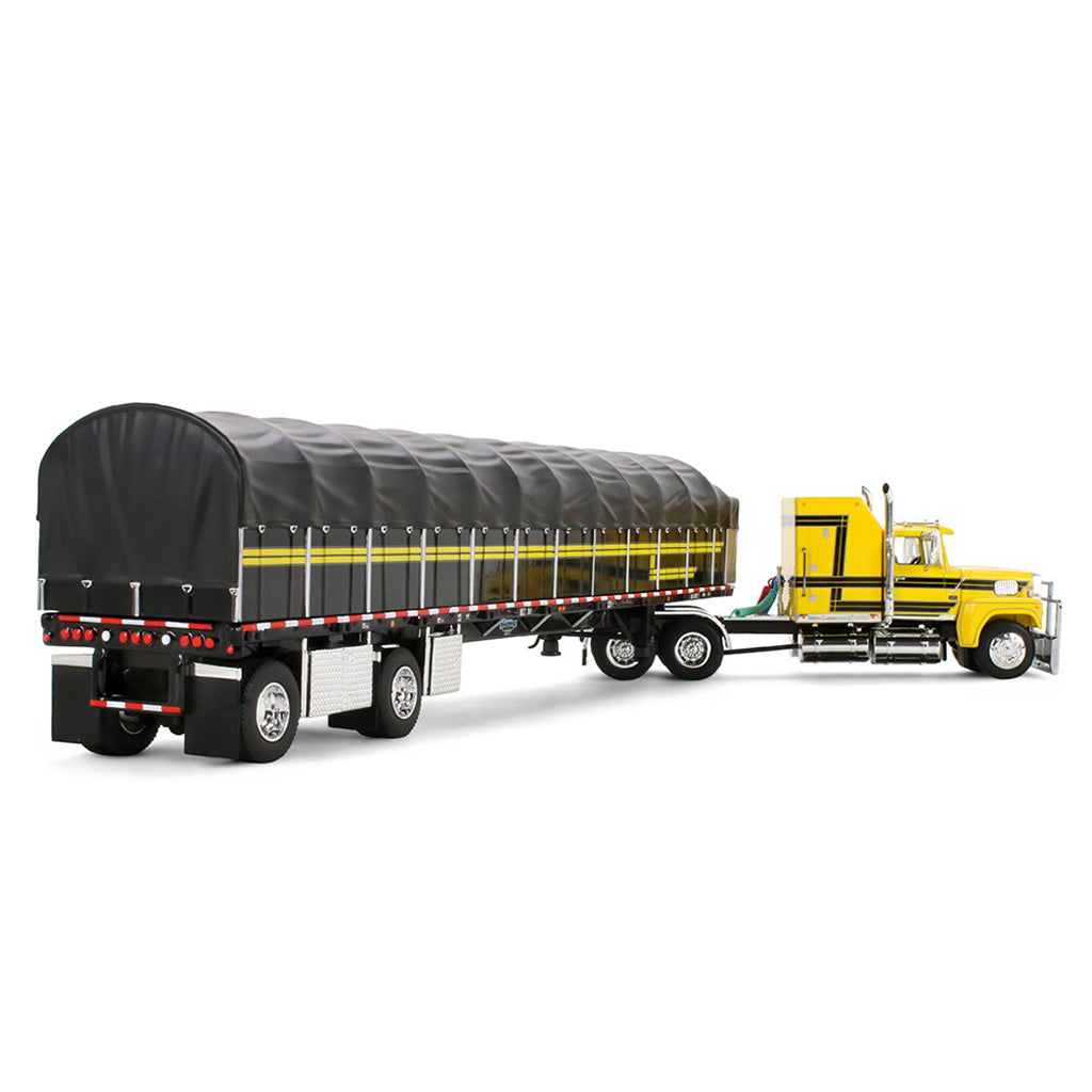 A model of a yellow semi-truck pulling a long black covered wagon trailer with yellow stripes, shown on a plain white background.