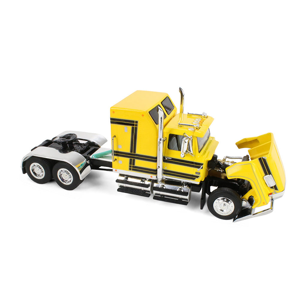 A yellow die-cast model semi-truck cab photographed on a clean white background.