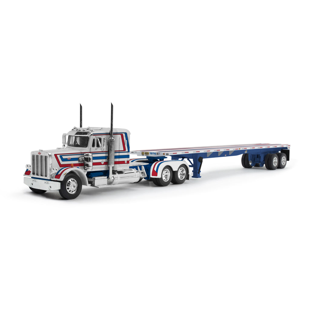 A die-cast model of a Peterbilt semi-truck with a flatbed trailer, featuring a white cab with red and blue stripes, on a white background.