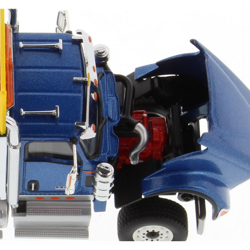 A close-up of a blue toy semi-truck cab with an open hood showing a red engine compartment, black wheels, chrome details, and orange reflective accents on a white background.