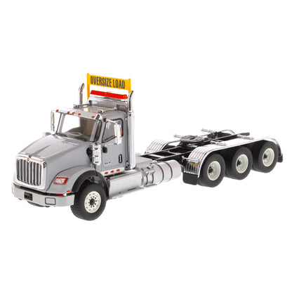 1:50 Scale Diecast Model of a Light Gray International HX620 Tri-Axle Day Cab Tractor on a White Background