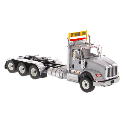 1:50 Scale Diecast Model of a Light Gray International HX620 Tri-Axle Day Cab Tractor on a White Background