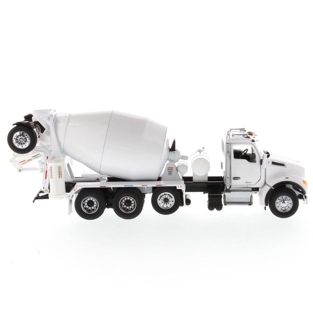 A white die-cast model of a Kenworth truck with a cement mixer drum, photographed on a seamless white background.