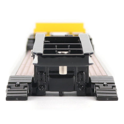 A miniature toy model of a Trail King TK120 lowboy trailer with a black frame, brown textured deck, and a yellow sign, shown on a solid white background.