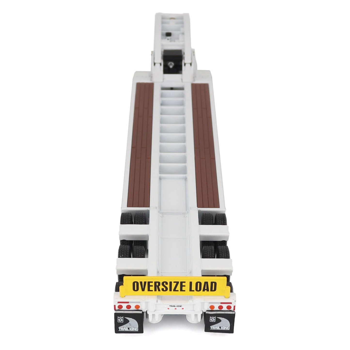 A miniature toy model of a Trail King TK120 lowboy trailer with a black frame, brown textured deck, and a yellow sign, shown on a solid white background.