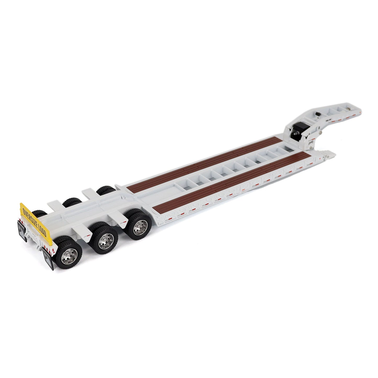A miniature toy model of a Trail King TK120 lowboy trailer with a black frame, brown textured deck, and a yellow sign, shown on a solid white background.