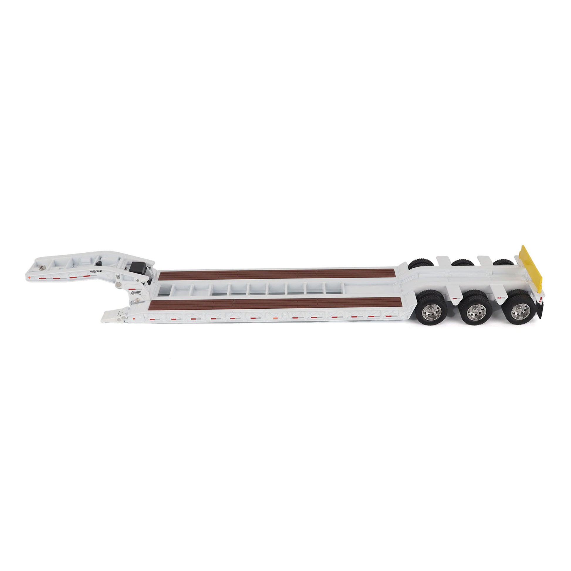 A miniature toy model of a Trail King TK120 lowboy trailer with a black frame, brown textured deck, and a yellow sign, shown on a solid white background.