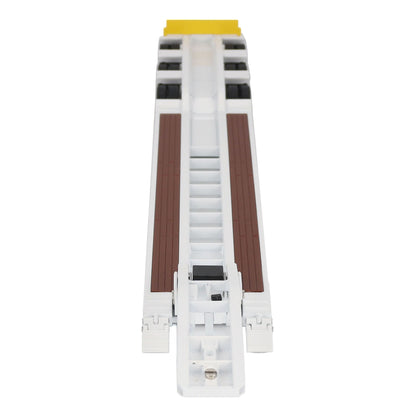 A miniature toy model of a Trail King TK120 lowboy trailer with a black frame, brown textured deck, and a yellow sign, shown on a solid white background.