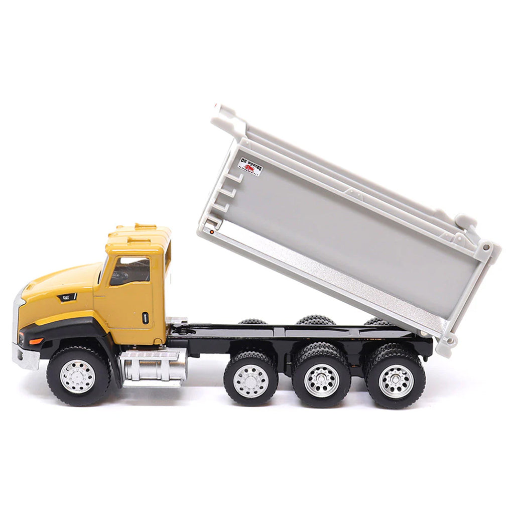 Toy CAT dump truck with yellow cab and gray bed on a white background