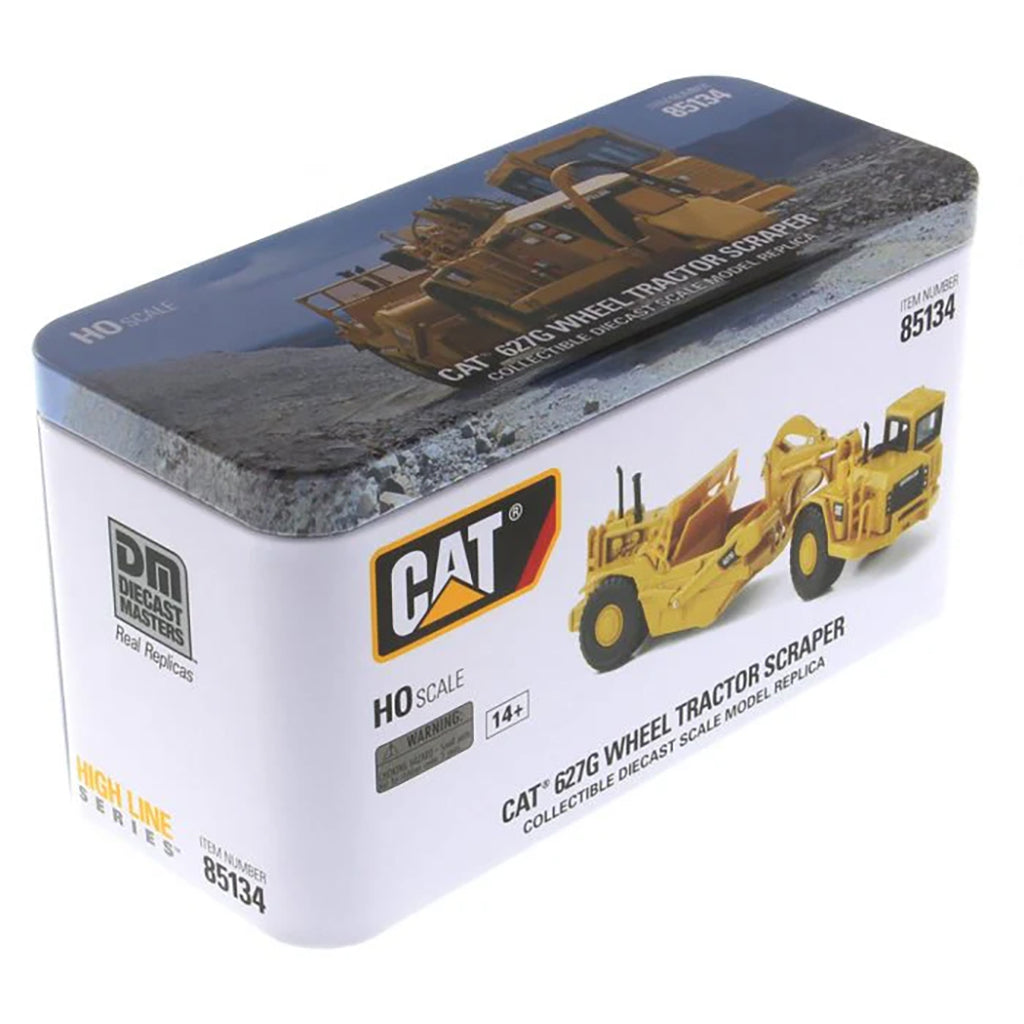Model of a Caterpillar 627G Wheel Tractor Scraper in Tin Box Packaging on a White Background
