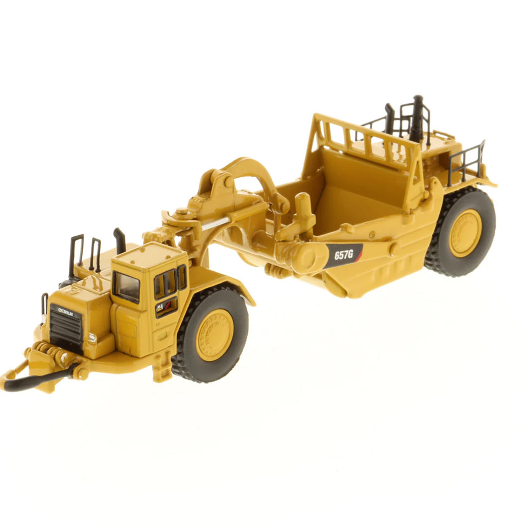 Model of a Caterpillar 657G Wheel Tractor Scraper on a White Background