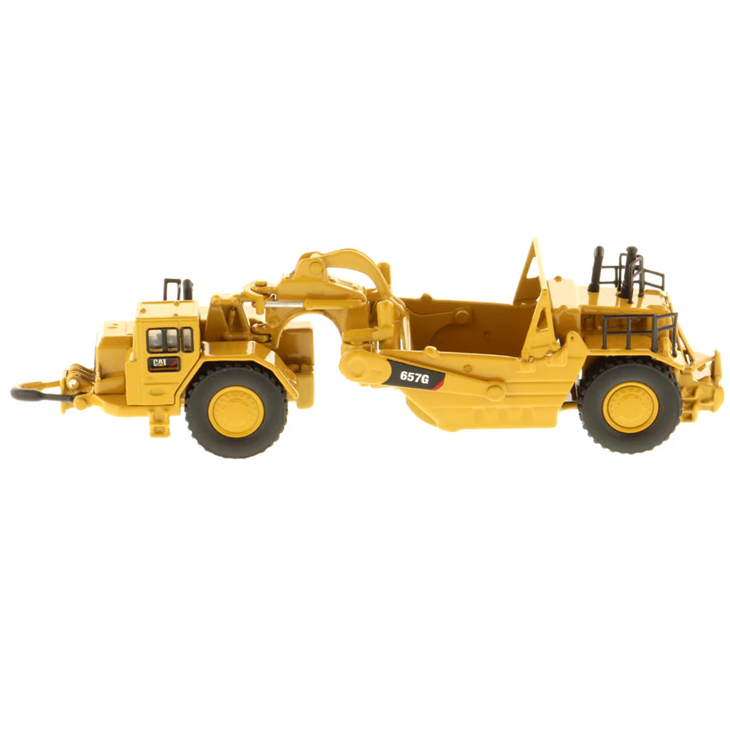 Model of a Caterpillar 657G Wheel Tractor Scraper on a White Background