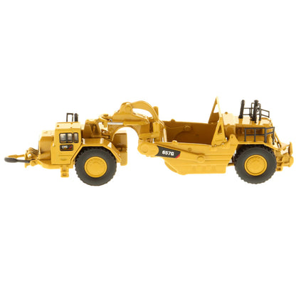 Model of a Caterpillar 657G Wheel Tractor Scraper on a White Background