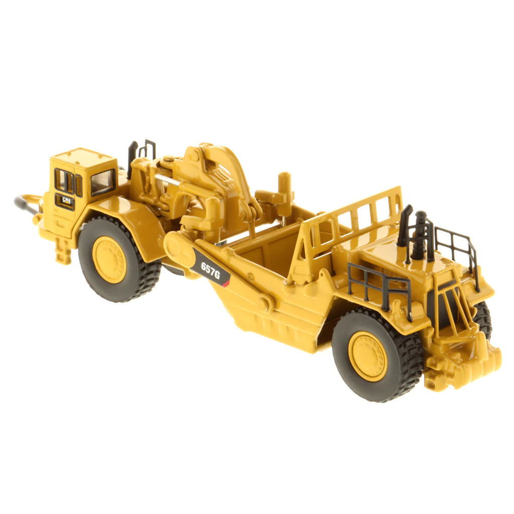 Model of a Caterpillar 657G Wheel Tractor Scraper on a White Background