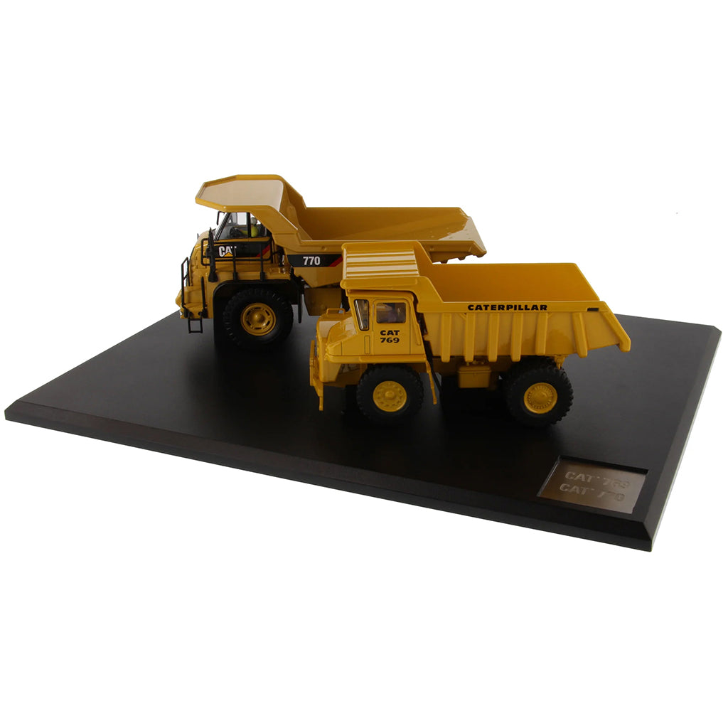 Models of Caterpillar 769 Off Highway Dump Truck (1963-1965) & Caterpillar 770 Off Highway Dump Truck (2013-Current) Mounted on a Black Base on a White Background