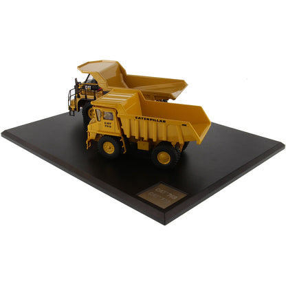 Models of Caterpillar 769 Off Highway Dump Truck (1963-1965) & Caterpillar 770 Off Highway Dump Truck (2013-Current) Mounted on a Black Base on a White Background