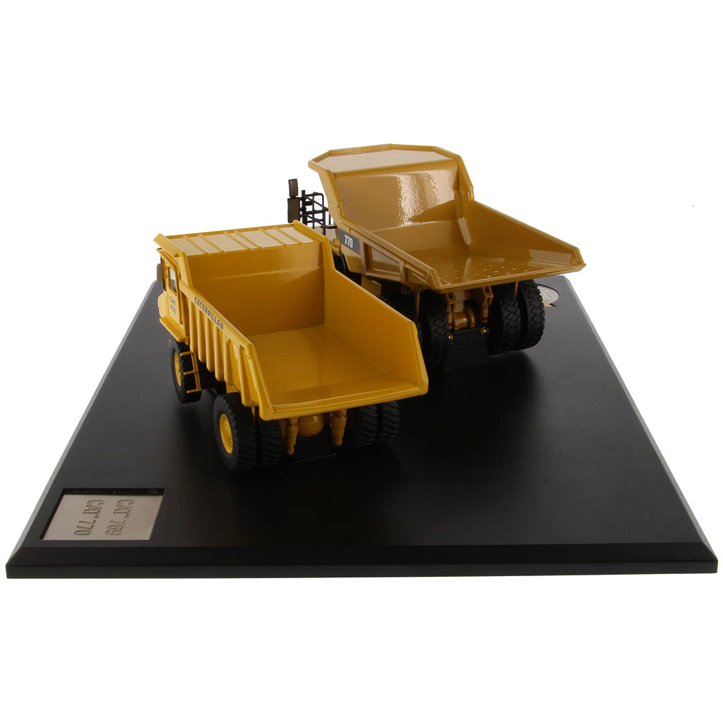Models of Caterpillar 769 Off Highway Dump Truck (1963-1965) & Caterpillar 770 Off Highway Dump Truck (2013-Current) Mounted on a Black Base on a White Background