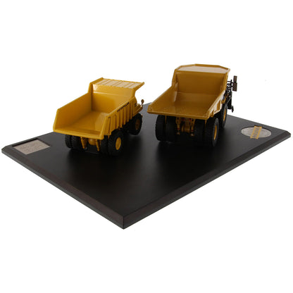 Models of Caterpillar 769 Off Highway Dump Truck (1963-1965) & Caterpillar 770 Off Highway Dump Truck (2013-Current) Mounted on a Black Base on a White Background