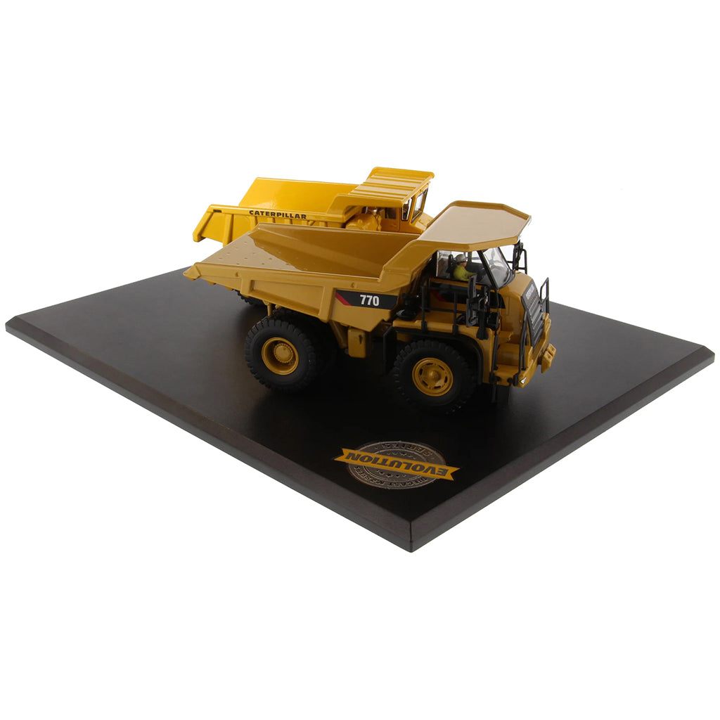 Models of Caterpillar 769 Off Highway Dump Truck (1963-1965) & Caterpillar 770 Off Highway Dump Truck (2013-Current) Mounted on a Black Base on a White Background