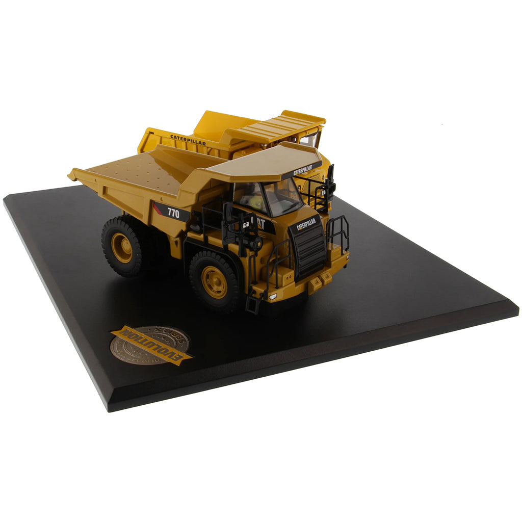 Models of Caterpillar 769 Off Highway Dump Truck (1963-1965) & Caterpillar 770 Off Highway Dump Truck (2013-Current) Mounted on a Black Base on a White Background