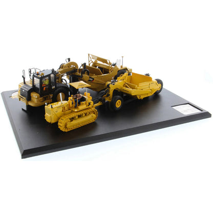 Models of Caterpillar D7 Track Type Tractor with No. 70 Scraper (1951-1957) &amp; Caterpillar 621K Scrape (2014-Current) Mounted on a Black Base on a White Background