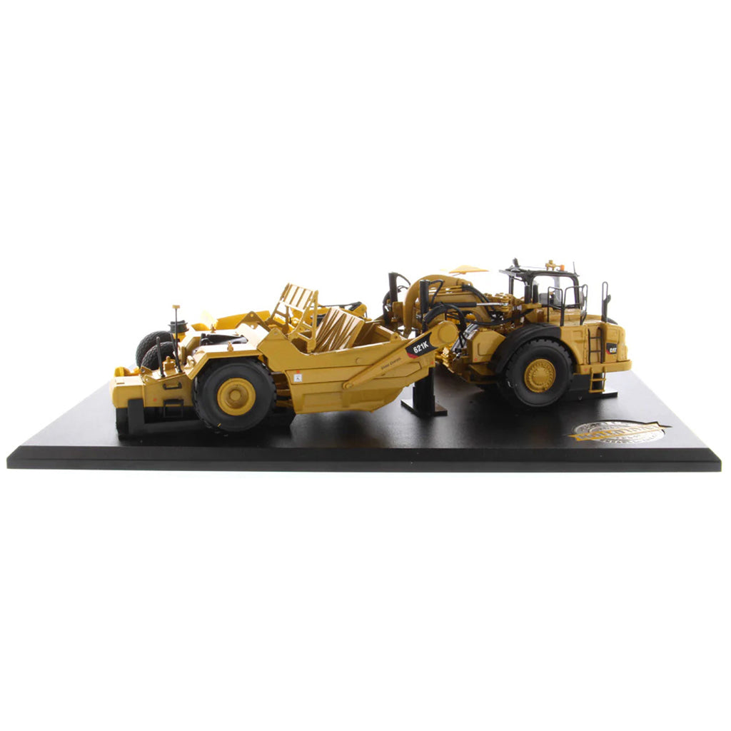 Models of Caterpillar D7 Track Type Tractor with No. 70 Scraper (1951-1957) &amp; Caterpillar 621K Scrape (2014-Current) Mounted on a Black Base on a White Background