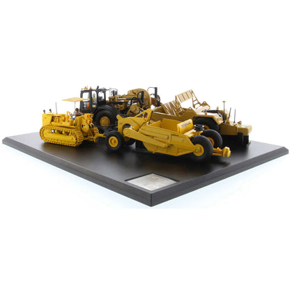 Models of Caterpillar D7 Track Type Tractor with No. 70 Scraper (1951-1957) &amp; Caterpillar 621K Scrape (2014-Current) Mounted on a Black Base on a White Background