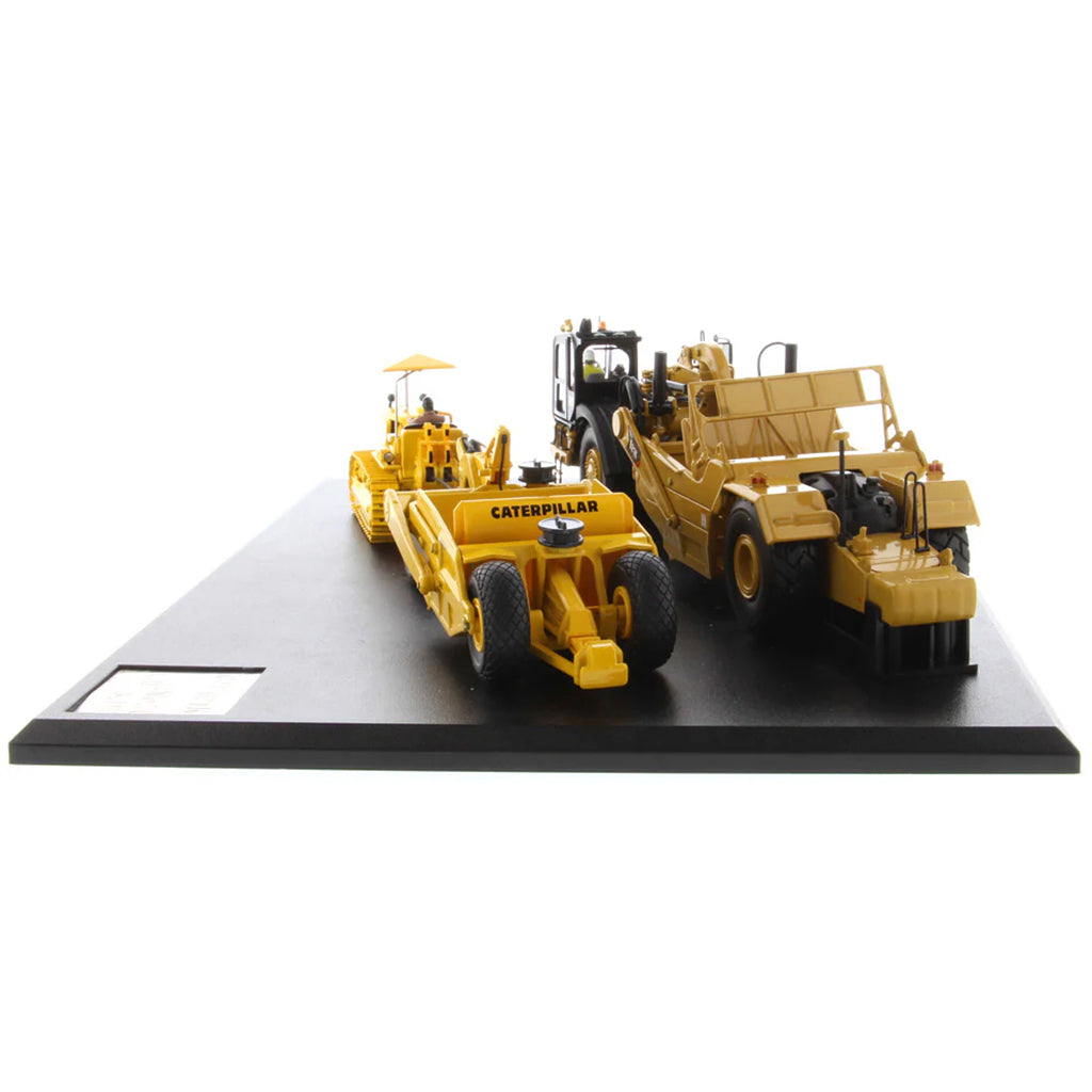 Models of Caterpillar D7 Track Type Tractor with No. 70 Scraper (1951-1957) &amp; Caterpillar 621K Scrape (2014-Current) Mounted on a Black Base on a White Background