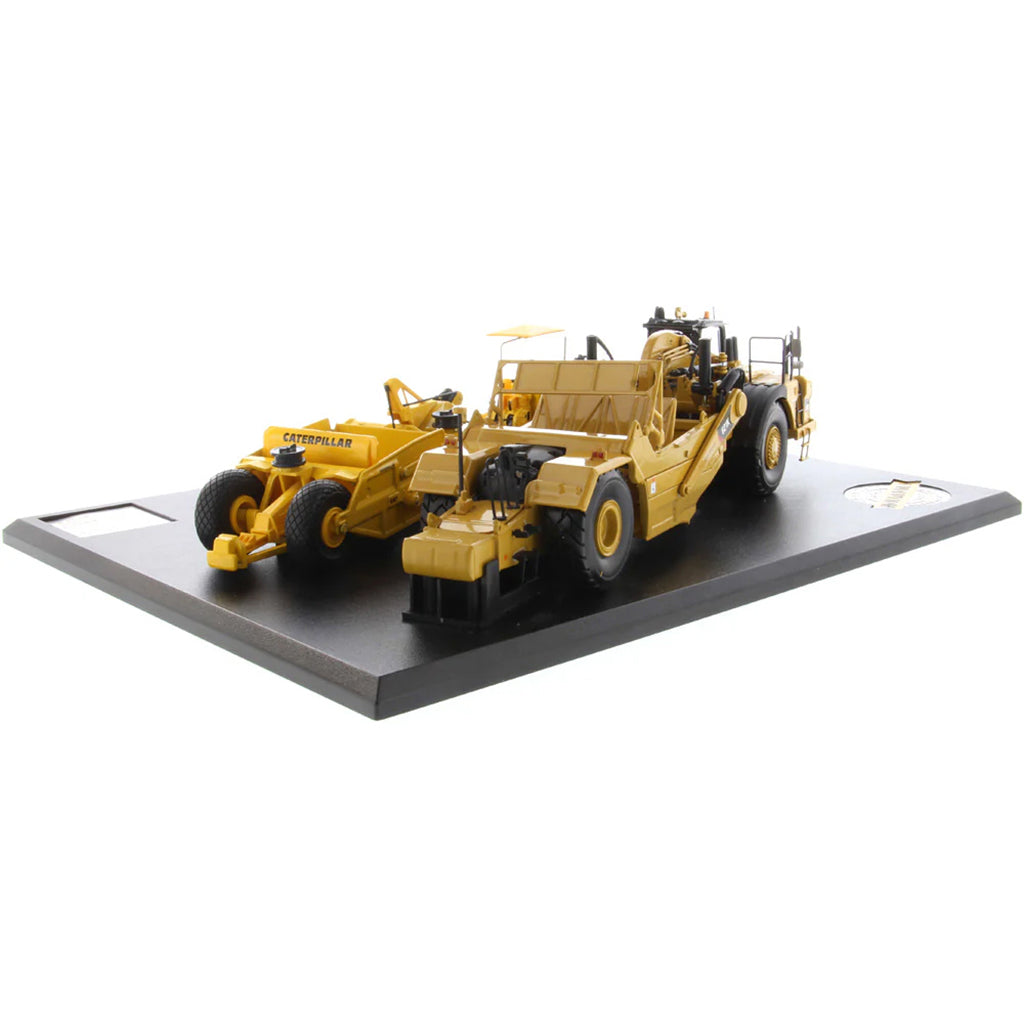 Models of Caterpillar D7 Track Type Tractor with No. 70 Scraper (1951-1957) &amp; Caterpillar 621K Scrape (2014-Current) Mounted on a Black Base on a White Background
