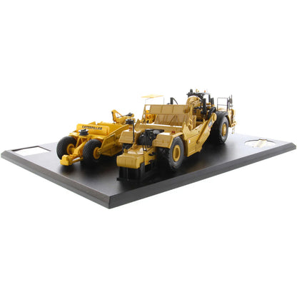 Models of Caterpillar D7 Track Type Tractor with No. 70 Scraper (1951-1957) &amp; Caterpillar 621K Scrape (2014-Current) Mounted on a Black Base on a White Background