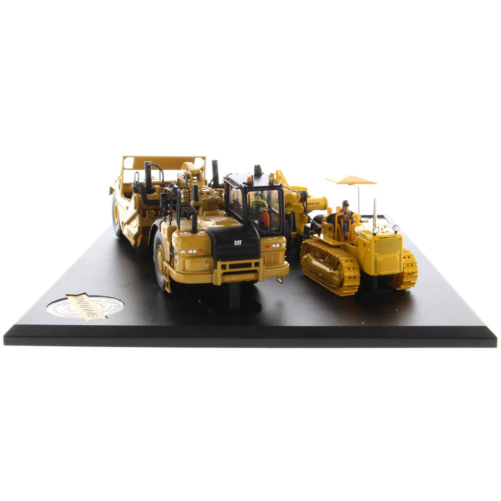 Models of Caterpillar D7 Track Type Tractor with No. 70 Scraper (1951-1957) &amp; Caterpillar 621K Scrape (2014-Current) Mounted on a Black Base on a White Background