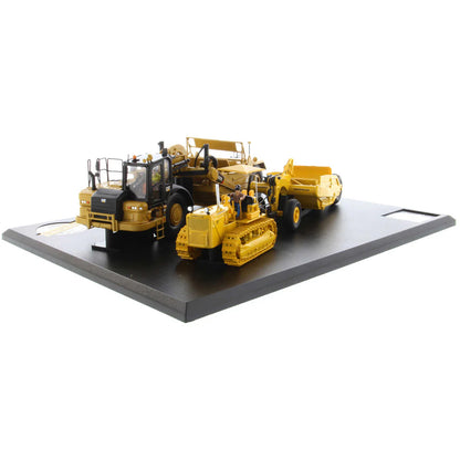 Models of Caterpillar D7 Track Type Tractor with No. 70 Scraper (1951-1957) &amp; Caterpillar 621K Scrape (2014-Current) Mounted on a Black Base on a White Background